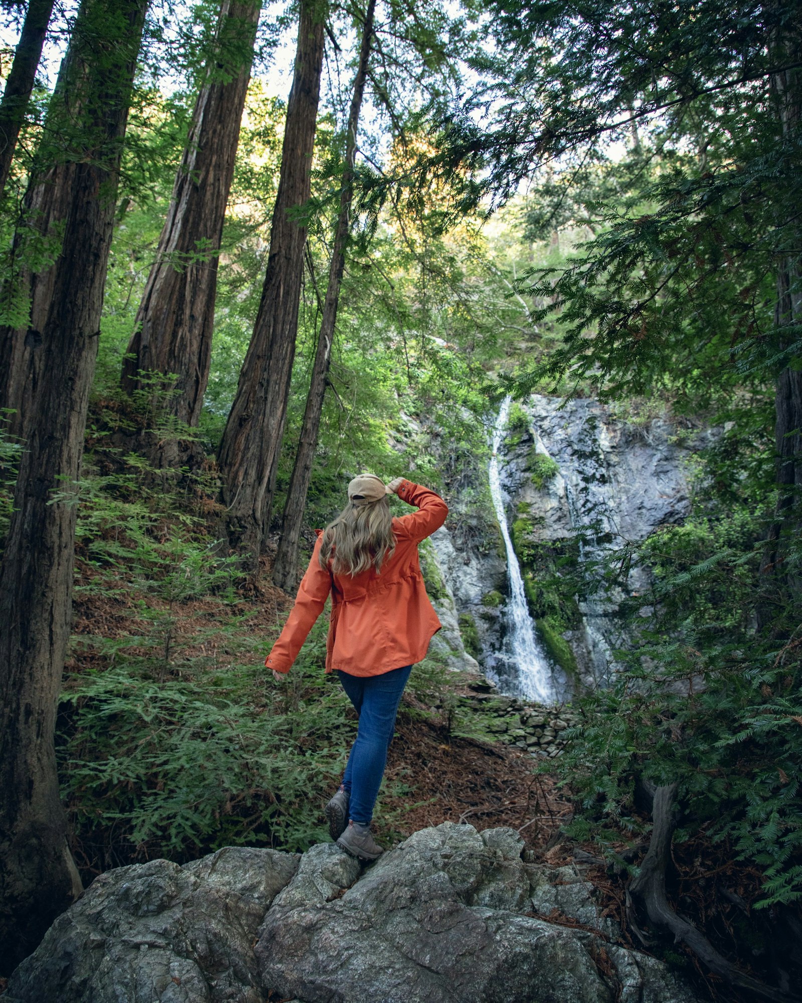 May contain: clothing, coat, plant, tree, vegetation, jacket, land, nature, outdoors, rainforest, grove, woodland, pants, person, photography, footwear, shoe, water, adventure, hiking, and leisure activities